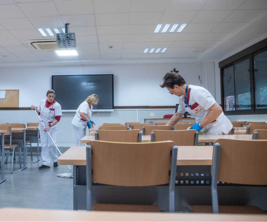 personas limpiando un aula de clase